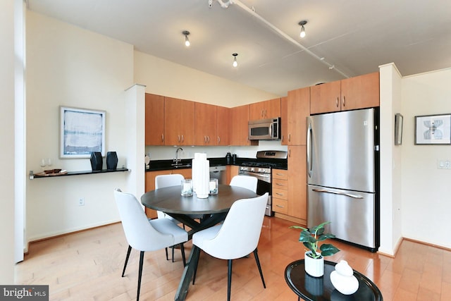 kitchen with sink, light wood-type flooring, and appliances with stainless steel finishes