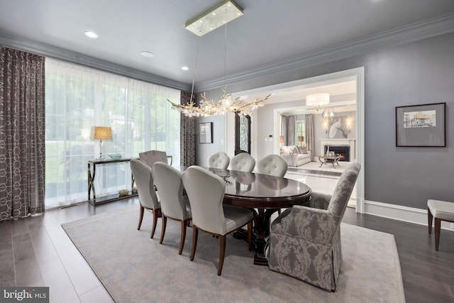 dining area featuring ornamental molding, an inviting chandelier, and dark hardwood / wood-style floors