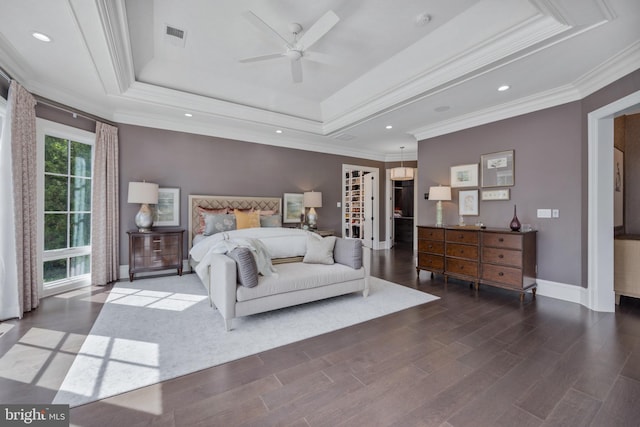 bedroom featuring wood-type flooring, ceiling fan, crown molding, and a tray ceiling