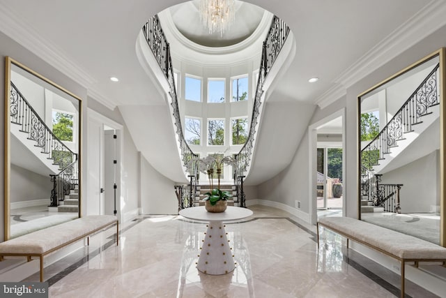 tiled foyer entrance with ornamental molding, a notable chandelier, and a wealth of natural light