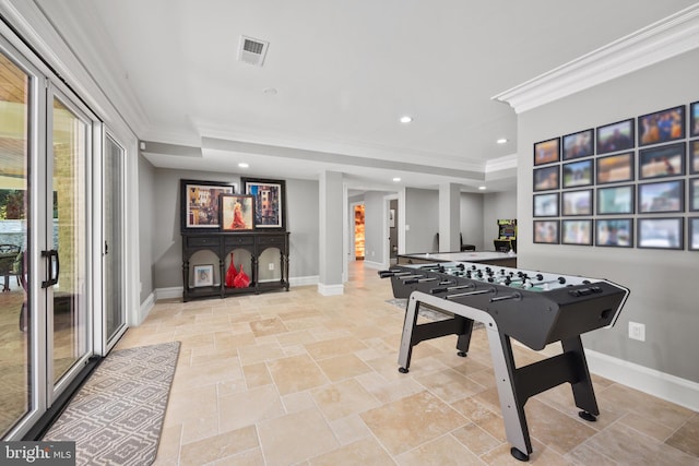 game room featuring light tile flooring, ornamental molding, and a tray ceiling