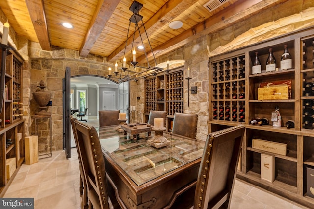 wine room featuring beamed ceiling, light tile floors, and wood ceiling