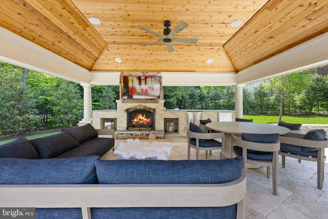 view of terrace featuring an outdoor living space with a fireplace and ceiling fan