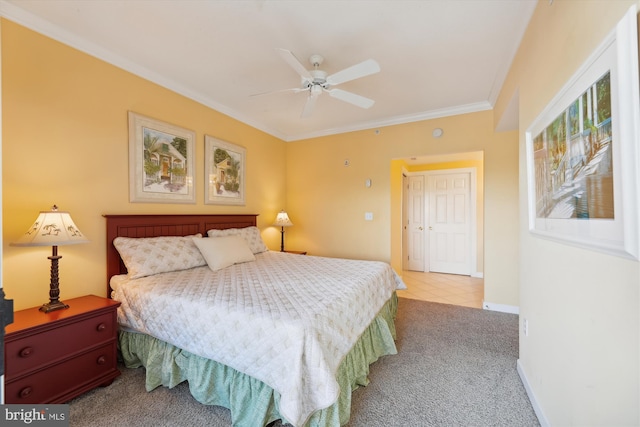 carpeted bedroom with a closet, ceiling fan, and ornamental molding