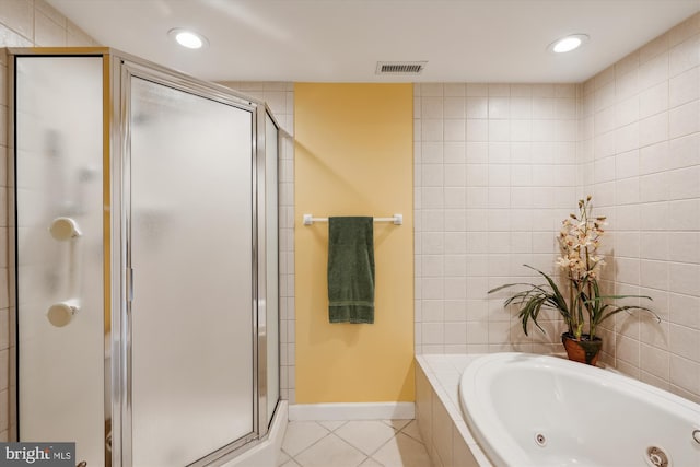 bathroom featuring tile flooring, independent shower and bath, and tile walls