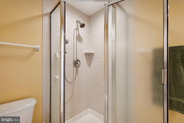 bathroom with walk in shower and toilet