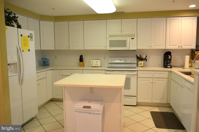 kitchen featuring a center island, white cabinetry, white appliances, sink, and light tile flooring