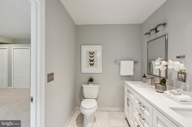 bathroom with tile patterned floors, toilet, and dual bowl vanity