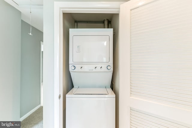 laundry area featuring stacked washer and clothes dryer and carpet