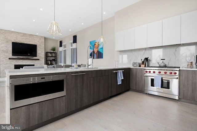 kitchen featuring appliances with stainless steel finishes, white cabinetry, dark brown cabinets, and backsplash