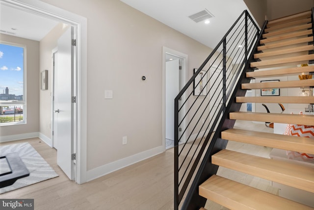 stairway with light hardwood / wood-style flooring