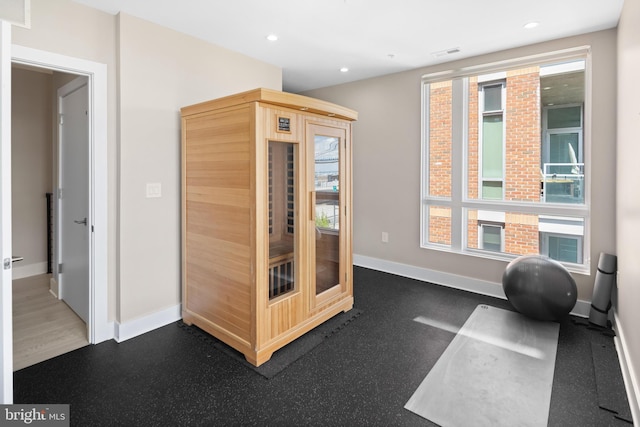 workout area with dark hardwood / wood-style floors and a healthy amount of sunlight