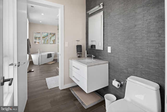 bathroom featuring vanity, toilet, and tile walls