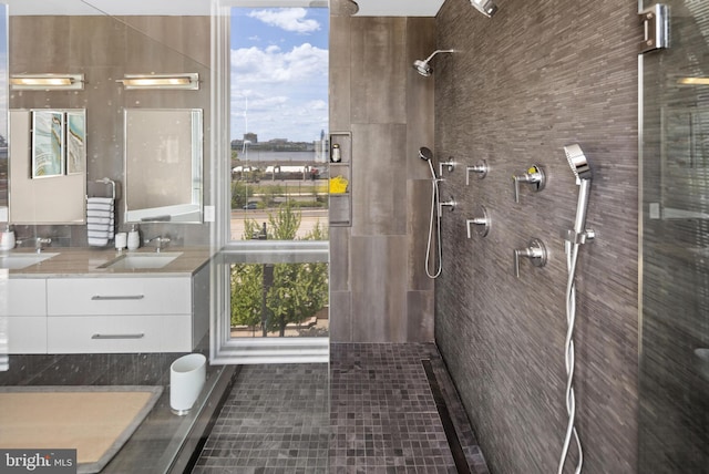 bathroom with tiled shower, vanity, tile patterned floors, and tile walls