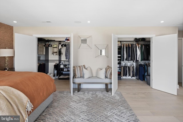 bedroom featuring two closets and light wood-type flooring