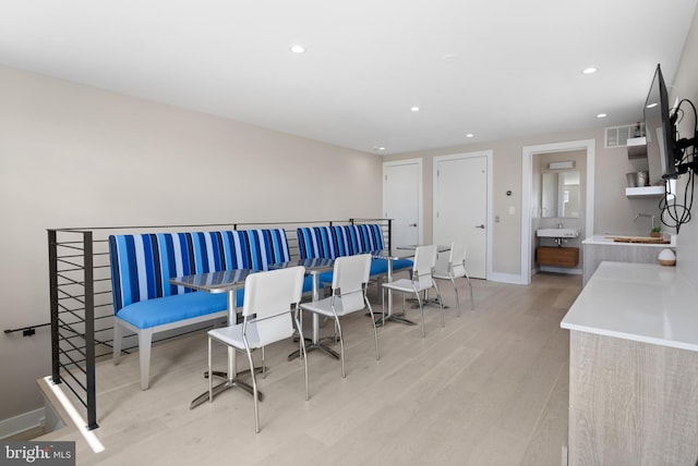 dining area featuring sink and light hardwood / wood-style flooring