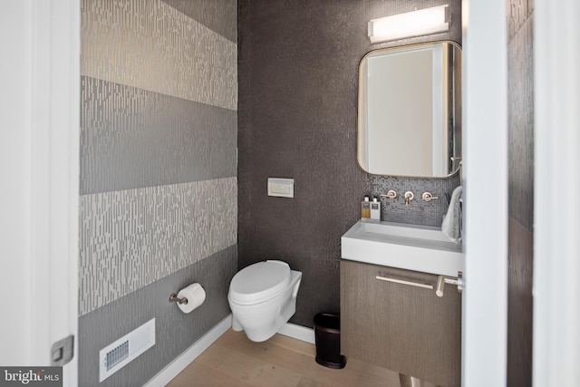 bathroom with vanity, toilet, and hardwood / wood-style floors