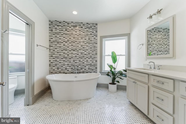 bathroom with tile walls, toilet, tile floors, and vanity