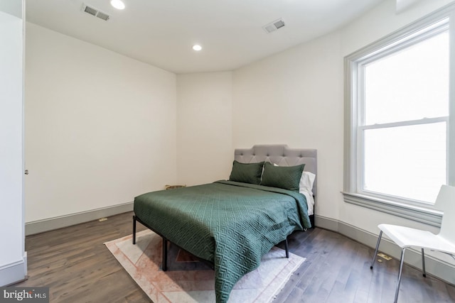 bedroom with hardwood / wood-style floors and multiple windows