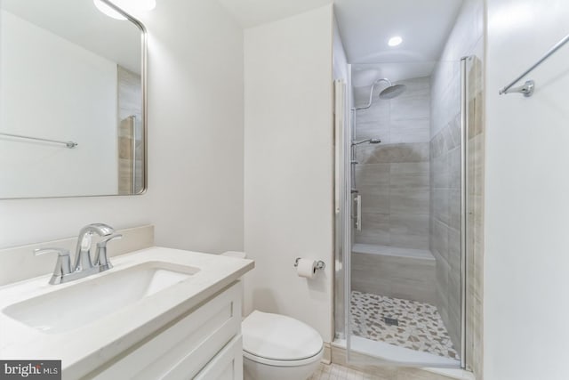 bathroom with walk in shower, vanity, and toilet