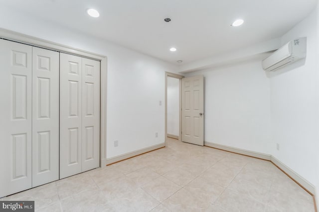 unfurnished bedroom featuring a closet, a wall unit AC, and light tile flooring