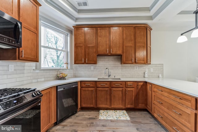 kitchen featuring backsplash, black appliances, sink, light wood-type flooring, and ornamental molding