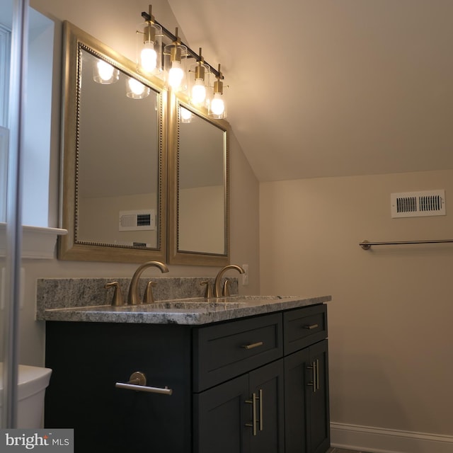 bathroom with vanity and vaulted ceiling