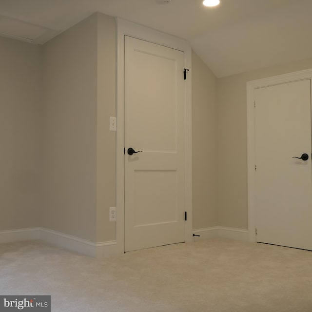 additional living space with light colored carpet and lofted ceiling