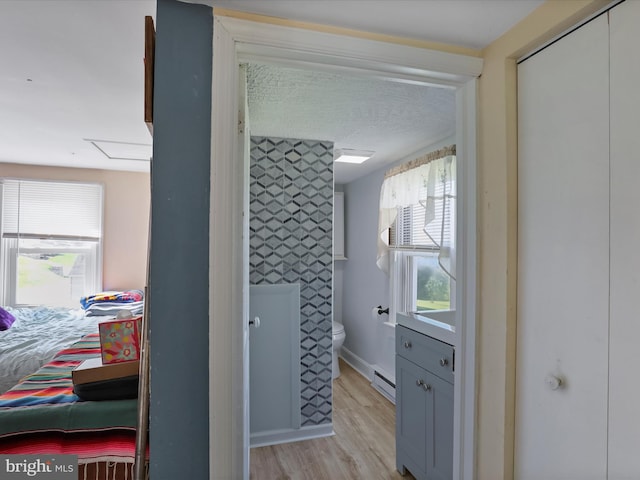 bathroom with hardwood / wood-style flooring and a baseboard radiator