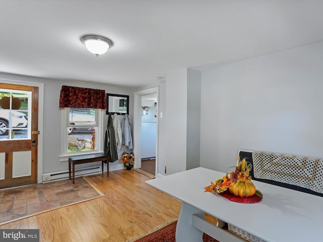 dining area with a baseboard radiator and wood-type flooring