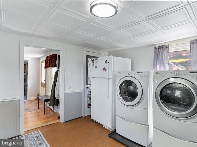 laundry area with independent washer and dryer and light wood-type flooring