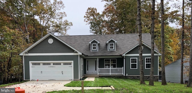 view of front of home with covered porch, a garage, and a front lawn