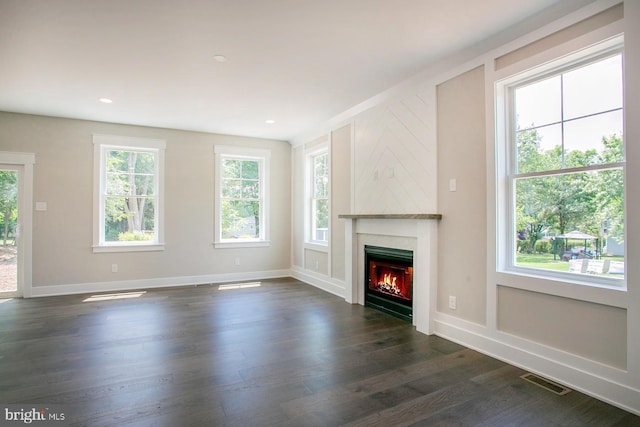 unfurnished living room with a large fireplace and dark wood-type flooring