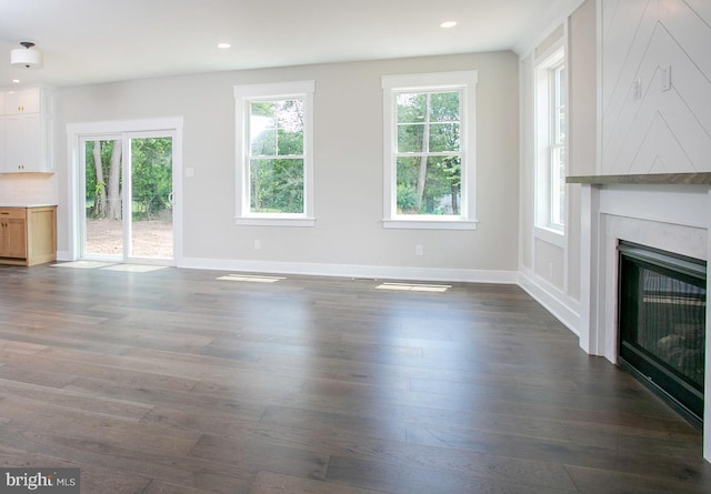 unfurnished living room with dark hardwood / wood-style floors and a wealth of natural light