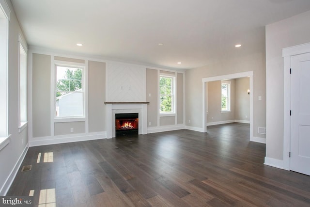 unfurnished living room featuring dark hardwood / wood-style floors and a large fireplace