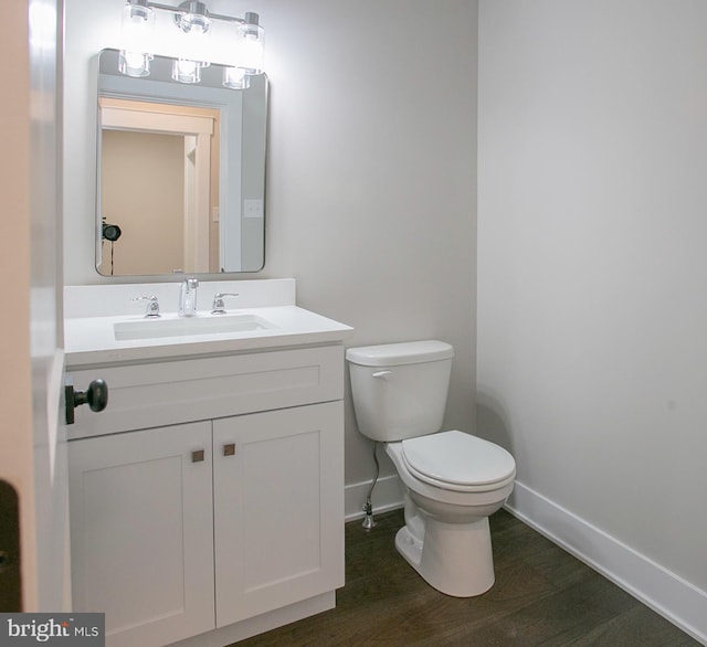 bathroom with hardwood / wood-style floors, vanity, and toilet