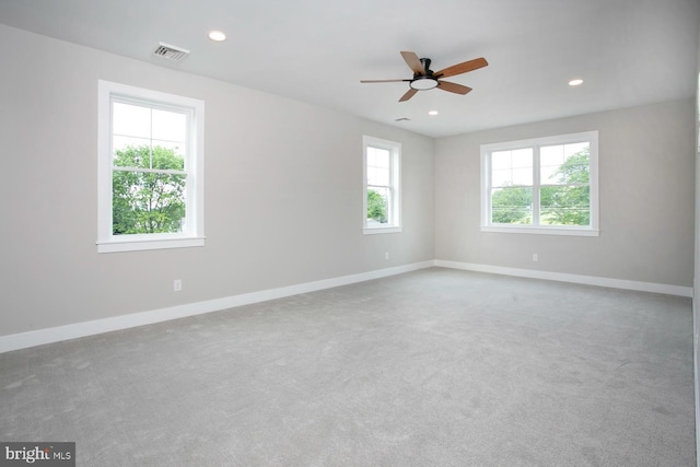 carpeted empty room with a wealth of natural light and ceiling fan