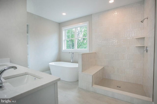 bathroom with vanity and shower with separate bathtub