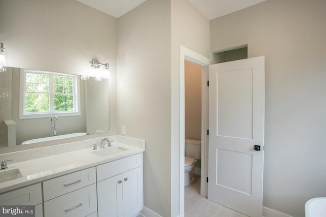 bathroom featuring a bath, vanity, and toilet