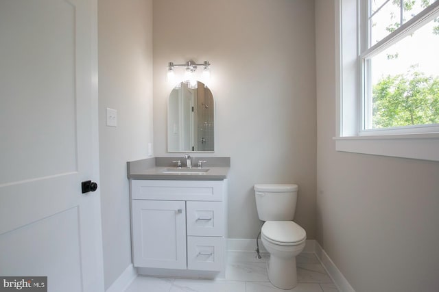 bathroom featuring plenty of natural light, vanity, and toilet