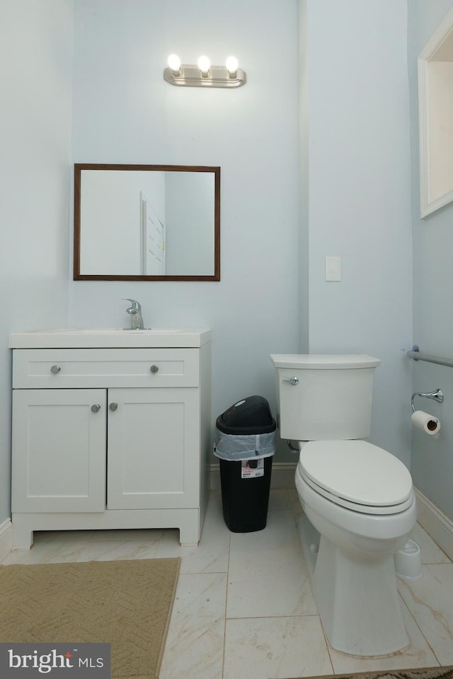 bathroom with toilet, tile flooring, and vanity