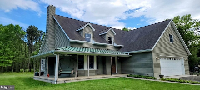 view of front of home featuring a chimney, covered porch, a standing seam roof, metal roof, and a front lawn