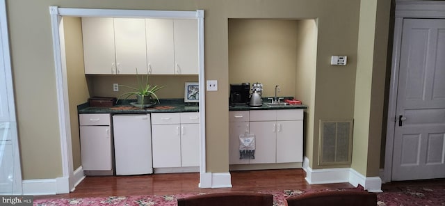 bar featuring refrigerator, sink, white cabinets, and hardwood / wood-style flooring