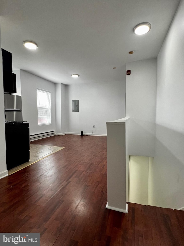 spare room with dark wood-type flooring and baseboard heating