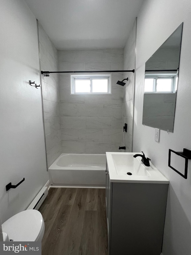 full bathroom featuring a healthy amount of sunlight, toilet, hardwood / wood-style flooring, and tiled shower / bath combo