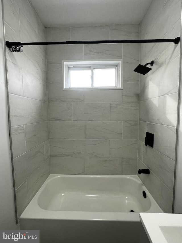 bathroom with tiled shower / bath and vanity