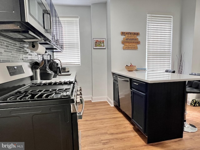 kitchen featuring tasteful backsplash, stainless steel appliances, and light hardwood / wood-style floors