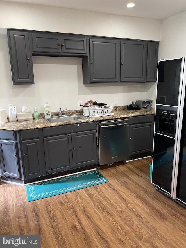 kitchen featuring hardwood / wood-style floors, sink, black fridge with ice dispenser, and stainless steel dishwasher