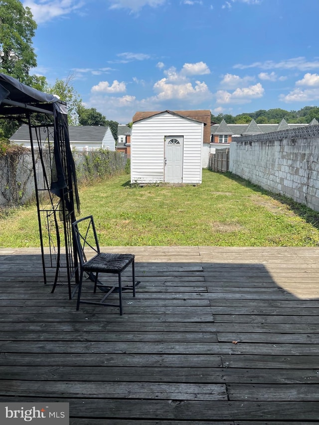 wooden terrace with a yard and a shed