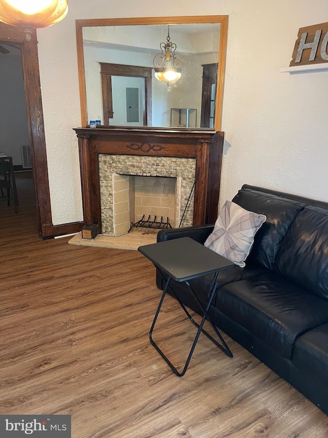 living room with hardwood / wood-style flooring and a stone fireplace